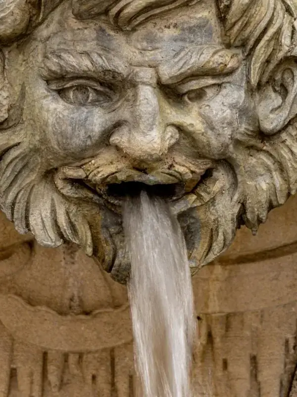 Stone fountain head with a smooth, silky stream
